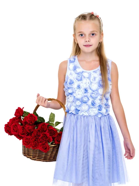 Schattig klein meisje met een mandje met bloemen. — Stockfoto