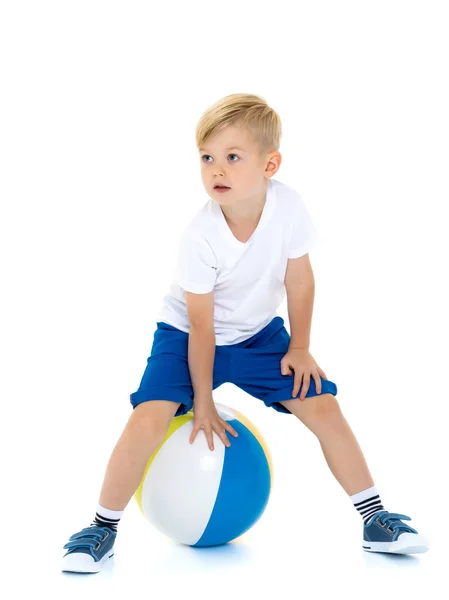 Um menino está brincando com uma bola . — Fotografia de Stock