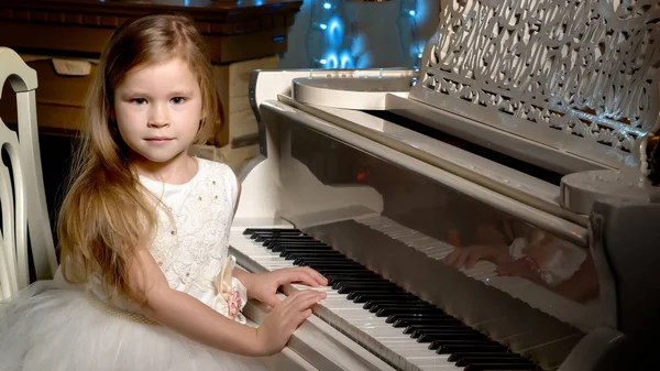 Menina toca piano à luz das velas. — Fotografia de Stock