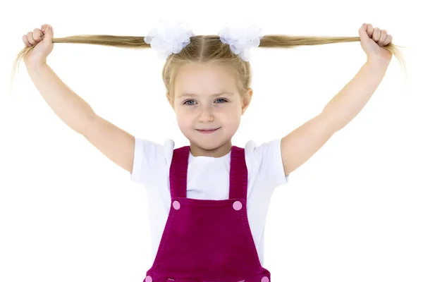 Ein kleines Mädchen fixiert ihre Haare. — Stockfoto