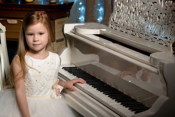 小女孩在烛光下弹钢琴. — 图库照片