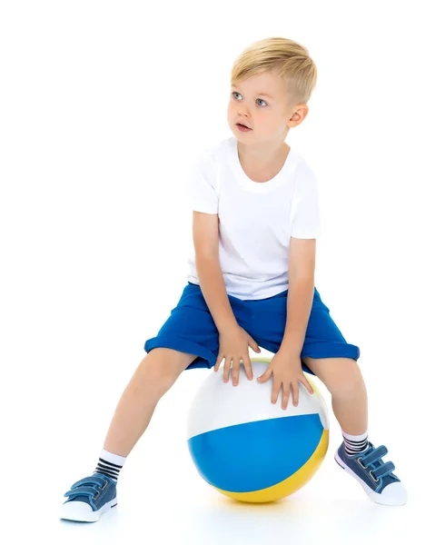 Um menino está brincando com uma bola . — Fotografia de Stock