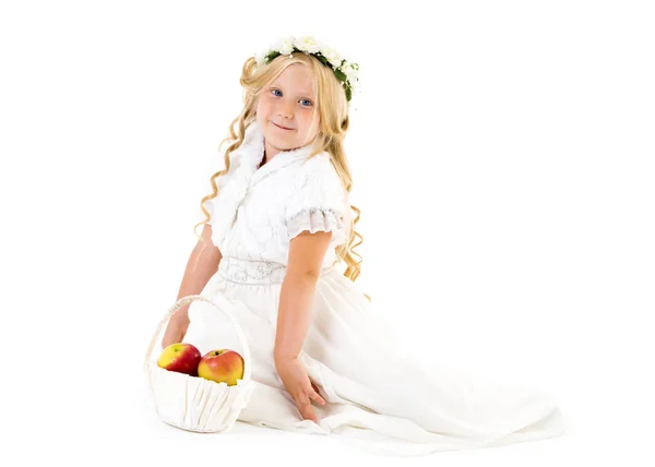 Klein meisje met een mand van appels. — Stockfoto