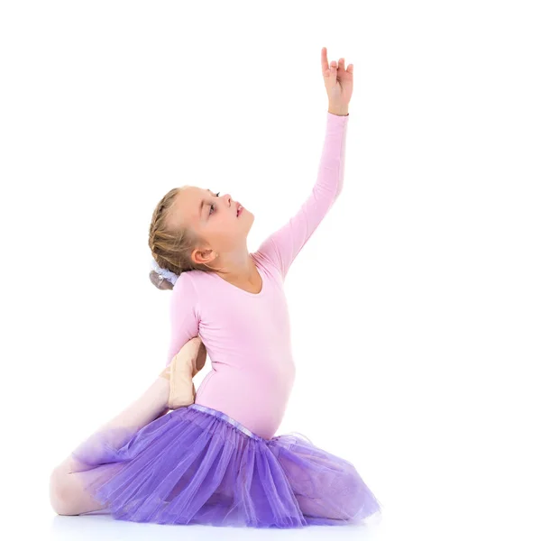 Liten flicka ballerina i bilden poserar på golvet. — Stockfoto