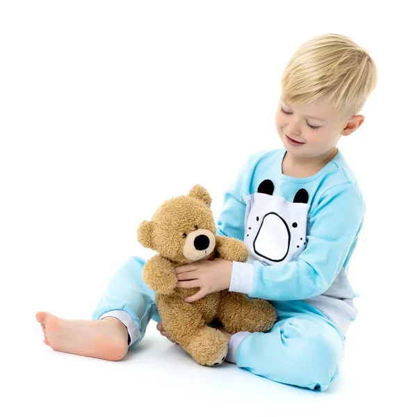 Niño en pijama con un osito de peluche . — Foto de Stock