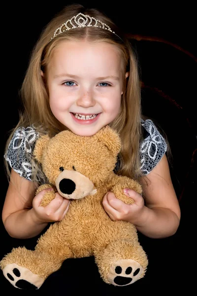 黑黑的背景上有个泰迪熊的小女孩. — 图库照片