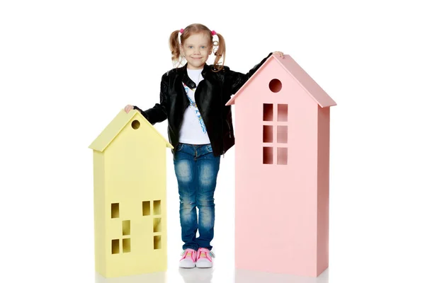 Petite fille joue avec des maisons en bois. — Photo