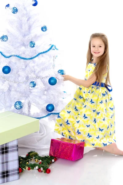 Una bambina sta decorando un albero di Natale . — Foto Stock