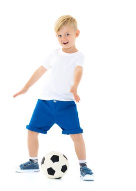 Küçük çocuk bir futbol topuyla oynuyor.
