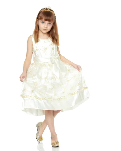A menina está segurando as bordas do vestido com as mãos . — Fotografia de Stock