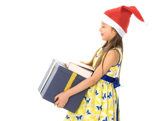Une petite fille avec un cadeau dans un chapeau du Père Noël . — Photo
