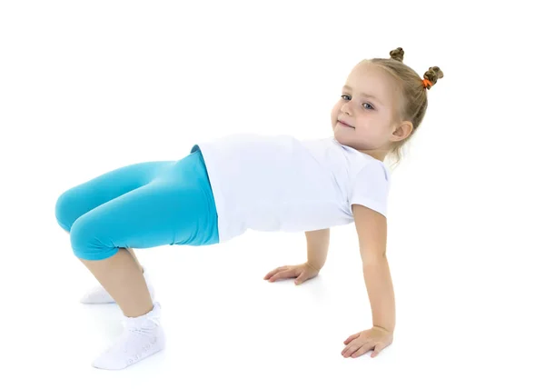 Mały gimnastyk wykonuje akrobatyczny element na podłodze.. — Zdjęcie stockowe