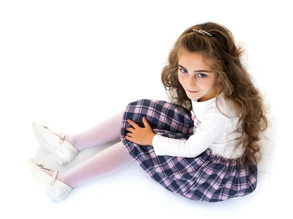 Den lilla flickan sitter på golvet.. — Stockfoto