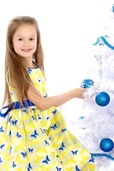 En liten flicka dekorera en julgran. — Stockfoto