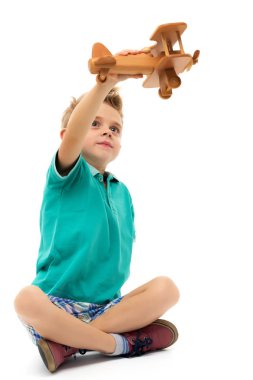 Küçük çocuk tahta uçakla oynuyor.