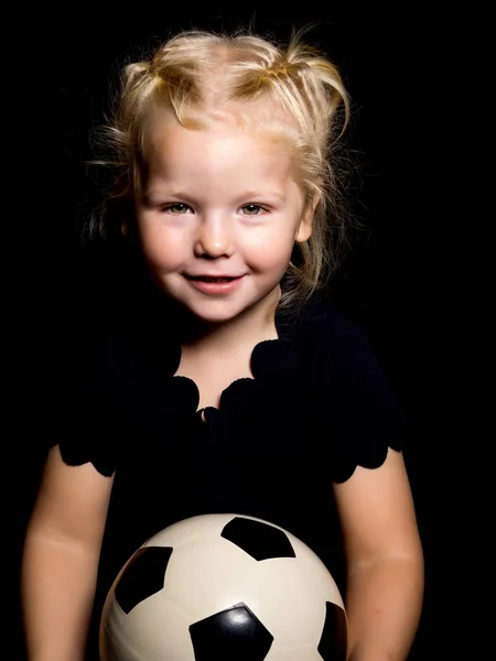 Kleines Mädchen mit einem Fußball auf schwarzem Hintergrund. — Stockfoto