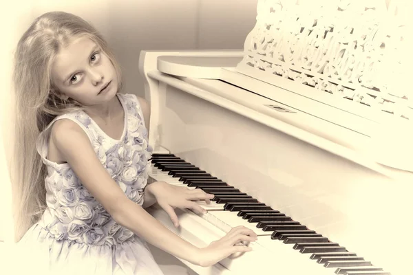 La fille est au piano à queue blanc. — Photo