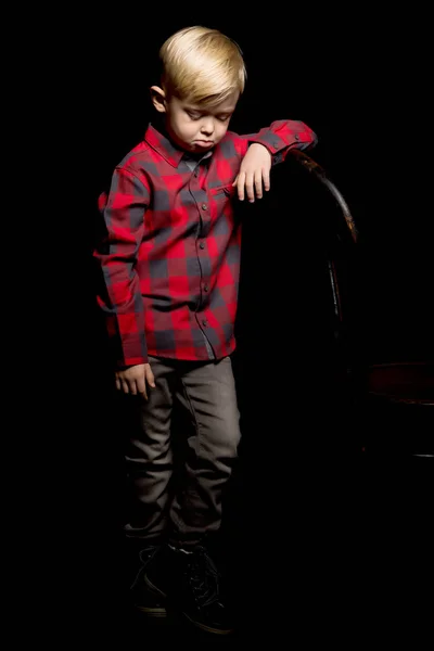 Kleine jongen op een zwarte achtergrond. — Stockfoto