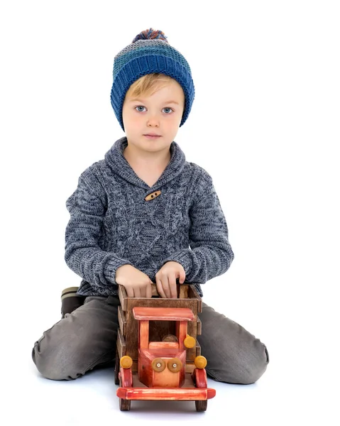 Malý chlapec hraje s dřevěné auto. — Stock fotografie