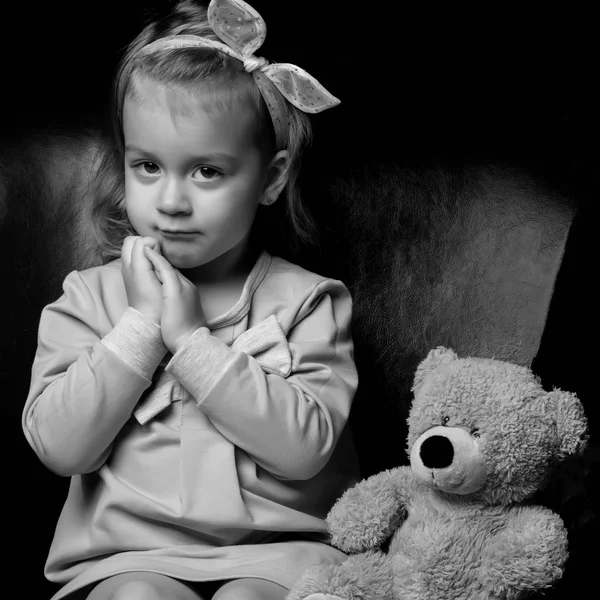 Kleines Mädchen mit einem Teddybär in Schwarz-Weiß Foto. — Stockfoto