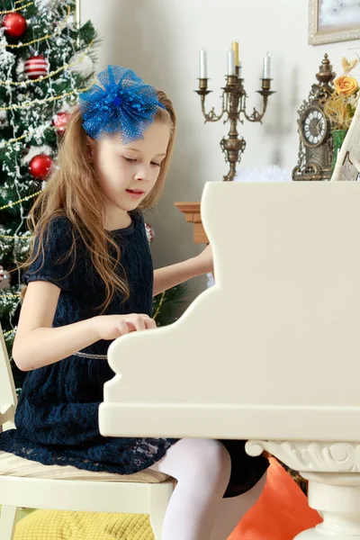Маленькая девочка за белым роялем . — стоковое фото