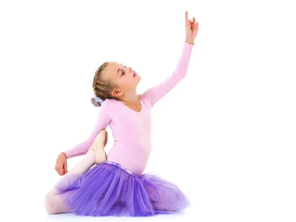 Liten flicka ballerina i bilden poserar på golvet. — Stockfoto