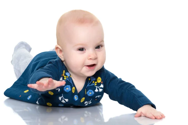 Een leuk, zeer weinig meisje ligt op de vloer op een witte backgr — Stockfoto