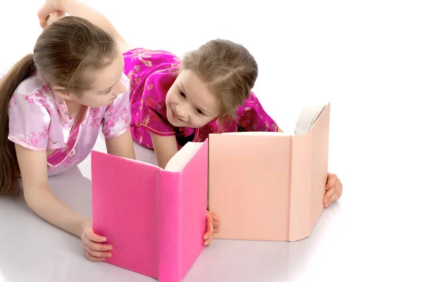 Дівчата-сестри читають книгу . — стокове фото