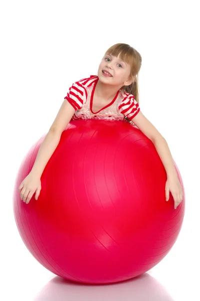 Kleines Mädchen macht Übungen auf einem großen Ball für Fitness. — Stockfoto