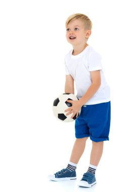 Küçük çocuk bir futbol topuyla oynuyor.