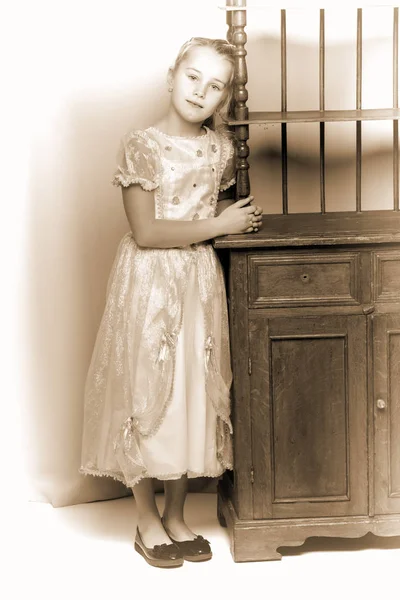 Mała dziewczynka, w pobliżu pięknego Starego stolik — Zdjęcie stockowe