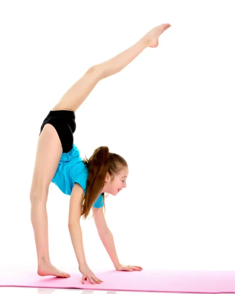 La pequeña gimnasta realiza un elemento acrobático en el suelo. —  Fotos de Stock
