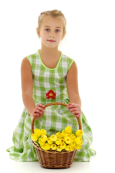 Niedliches kleines Mädchen mit einem Korb voller Blumen. — Stockfoto