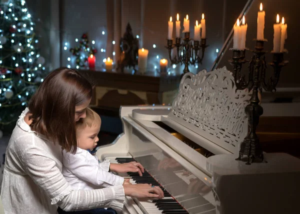 Bir çocuğun yanında beyaz piyano ile anne — Stok fotoğraf