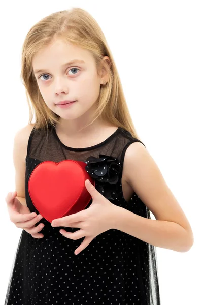 Uma menina está segurando um coração . — Fotografia de Stock