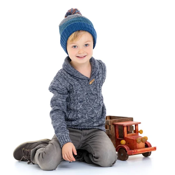 Malý chlapec hraje s dřevěné auto. — Stock fotografie
