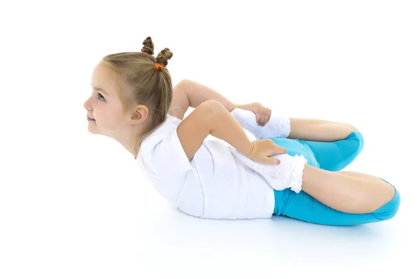 La petite gymnaste exécute un élément acrobatique sur le sol. — Photo
