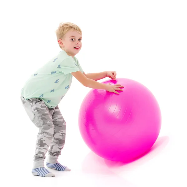 Um menino está brincando com uma bola . — Fotografia de Stock