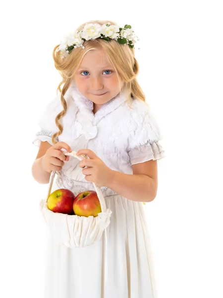 Kleines Mädchen mit einem Korb voller Äpfel. — Stockfoto