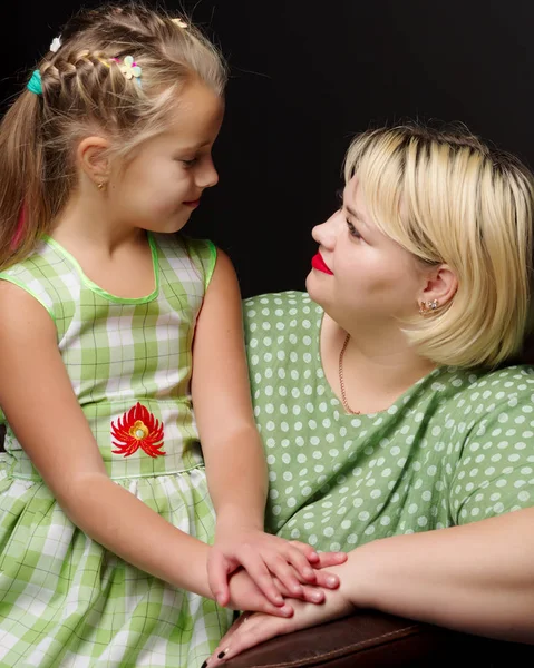 Mutter und Tochter umarmen sich auf schwarzem Hintergrund. — Stockfoto