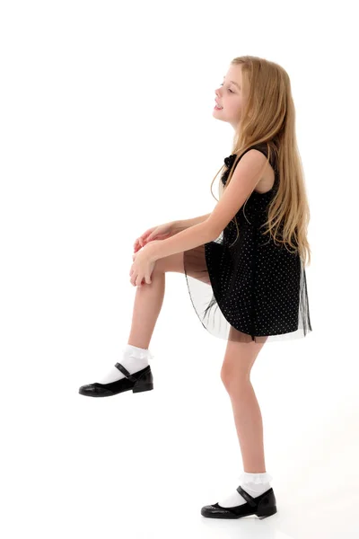 The little girl is standing on one leg. — Stock Photo, Image