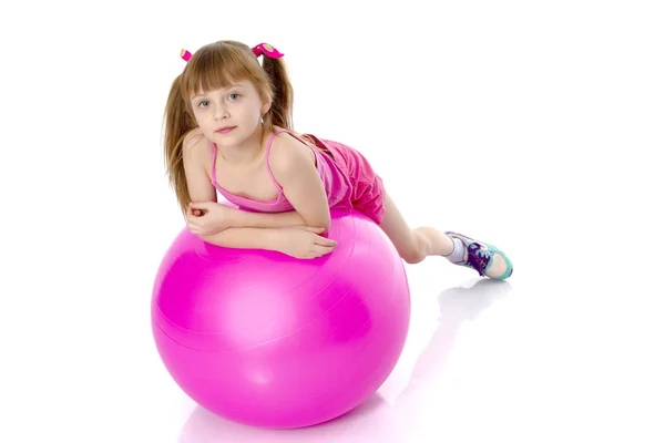 Niña haciendo ejercicios en una pelota grande para la aptitud. — Foto de Stock