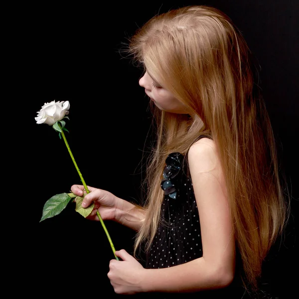 Siyah bir zemin üzerine beyaz çiçekli küçük kız. — Stok fotoğraf