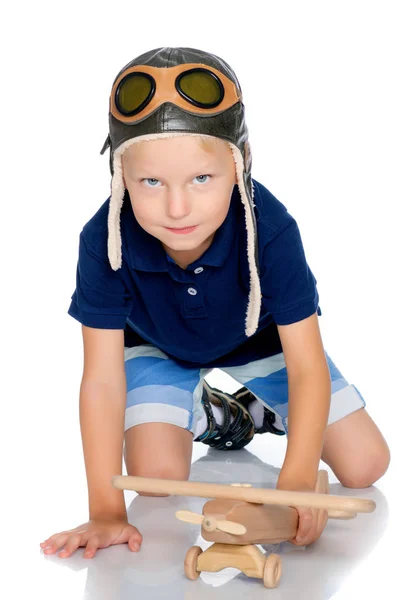 Kleiner Junge mit einem hölzernen Flugzeug. — Stockfoto