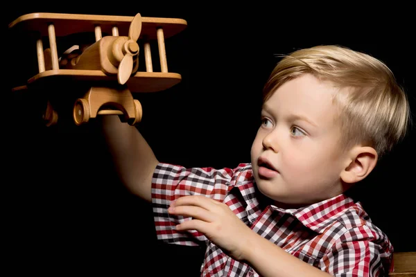 Petit garçon jouant avec un avion en bois — Photo