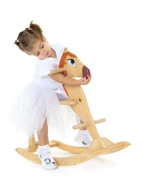 Mädchen schwingt auf einem Holzpferd. — Stockfoto