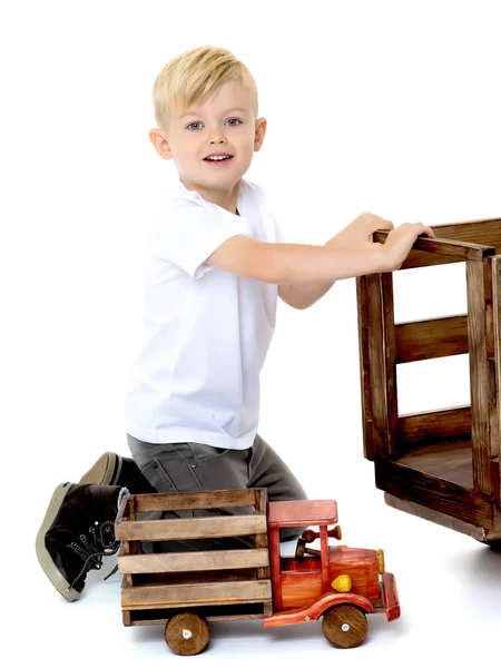 Мальчик играет с деревянной машиной . — стоковое фото