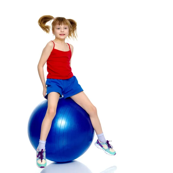 Маленькая девочка прыгает на большой гимнастический мяч . — стоковое фото