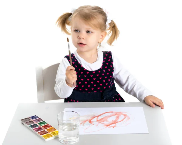 Ein kleines Mädchen zeichnet am Tisch. — Stockfoto