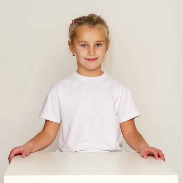 Девочка-школьница сидит за столом . — стоковое фото